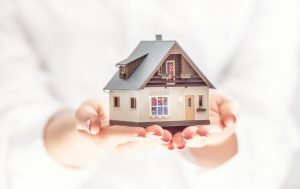 Hands,Of,Young,Woman,Holding,Model,House,,Real,Estate,Insurance